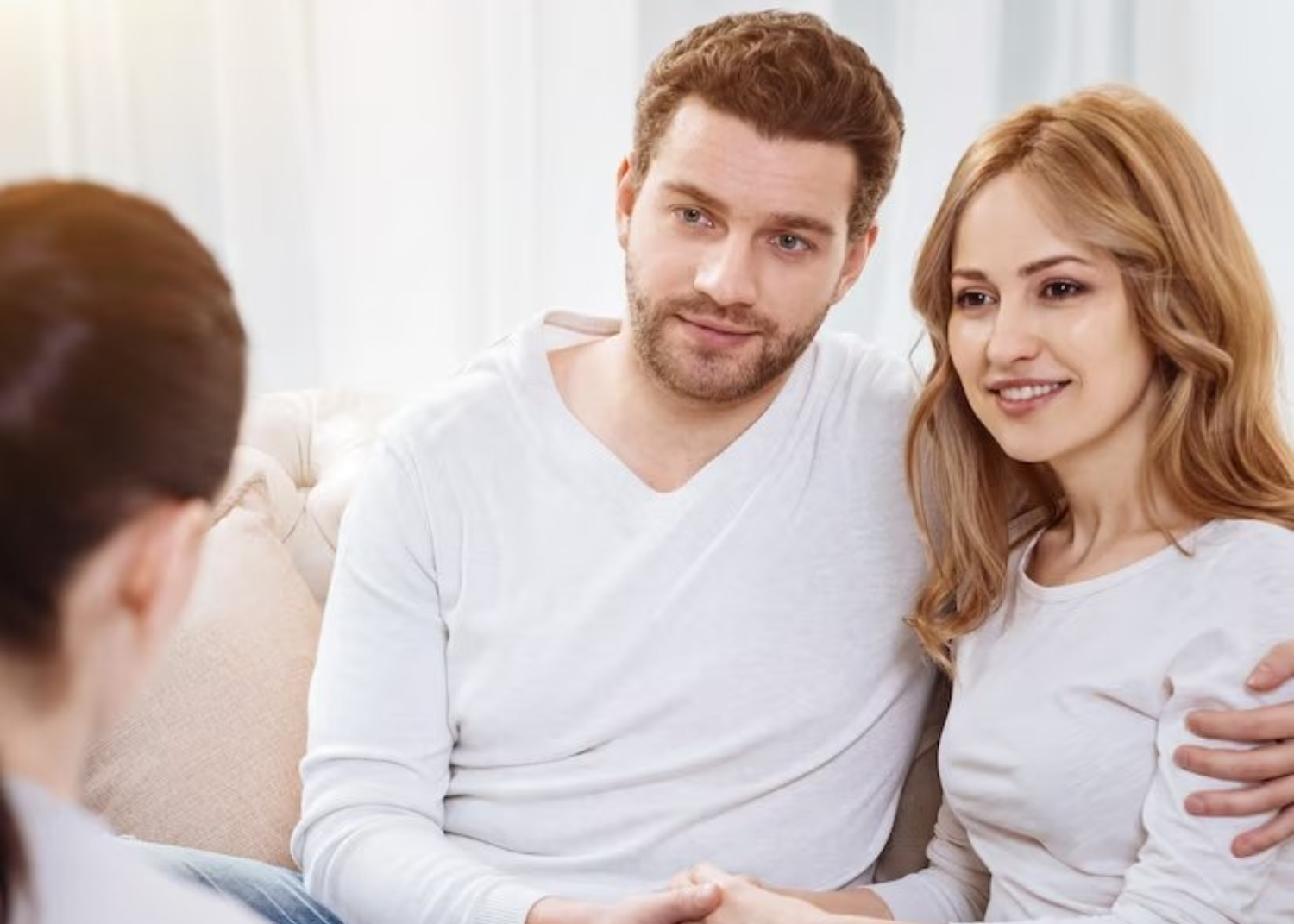 Couple sitting together in a counselling session, engaged in open conversation with a therapist